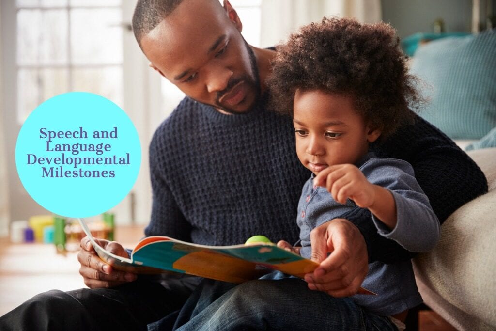African American black father and young son reading a book together at home.