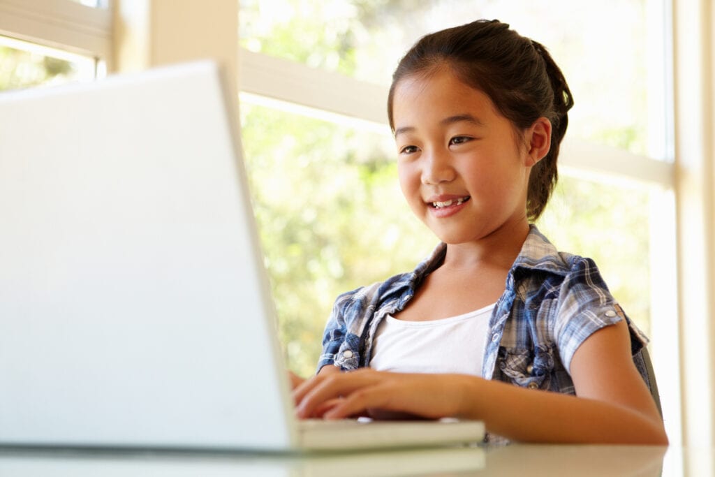 Young Asian girl at home using laptop