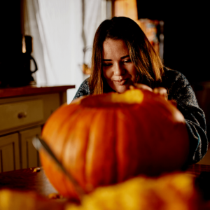 girl carving pumpkin